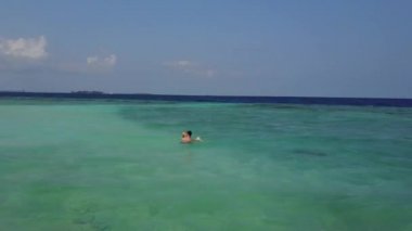 Hava dron kamera çift Hint Okyanusu üzerinde boş bir plaj yüzme etrafında sinekler. Banyo ve yukarıdaki mavi zümrüt Denizde öpüşme balayı iki lovers görüntüleri