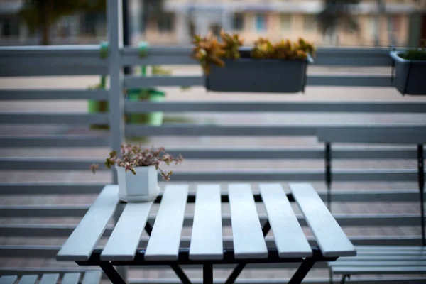 Mesa de tablones de madera blanca, sillas y valla horizontal de café en la calle. Fondo para la colocación del producto. Aislado al aire libre vacío europeo restaurante o cafetería exterior. No hay gente . —  Fotos de Stock