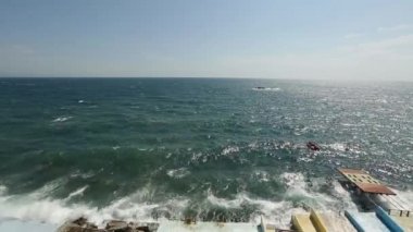 Büyük dalgalar hakkında waterfront sıçramasına ve cam gibi deniz suyu damla mavi gökyüzünde püskürtme set of breaking. Rüzgarlı bir gün denizde fırtına. Şişme tekne dalgalar kayalar. Sakinleştirici görüntüleri.