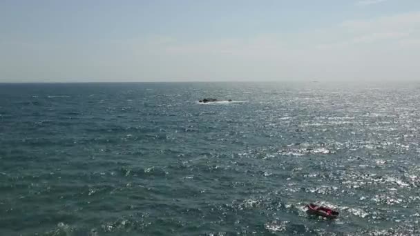Vagues énormes se brisant sur le front de mer des éclaboussures de remblai et pulvériser des gouttes d'eau de mer vitreuse dans le ciel bleu. Tempête dans la mer par temps venteux. Bateau gonflable roche sur les vagues. Images apaisantes .