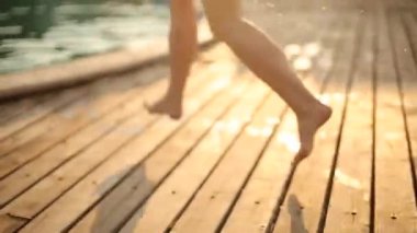 Genç kadın sıcak güneşli su sıçramalarına ve sprey yavaş hareket ile ferahlık için açık mavi havuzu suya atlama yaz tatilde. Boş lüks resort havuz içine dalış mavi bikinili kız.