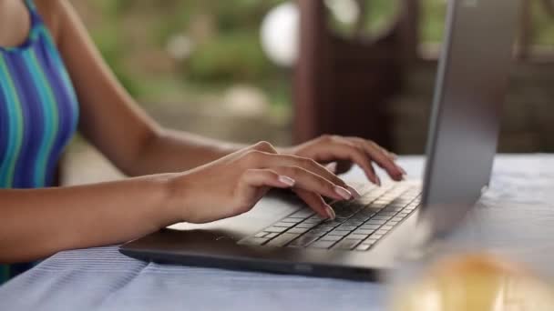 Closeup της γυναίκας freelancer τα χέρια typping στο πληκτρολόγιο του laptop στην τροπική καλοκαίρι θέση και εργάζονται εξ αποστάσεως με μαγιό. Ταξιδεύοντας με υπολογιστή και 4g 5g wi-fi internet. Έννοια της τηλεργασίας — Αρχείο Βίντεο