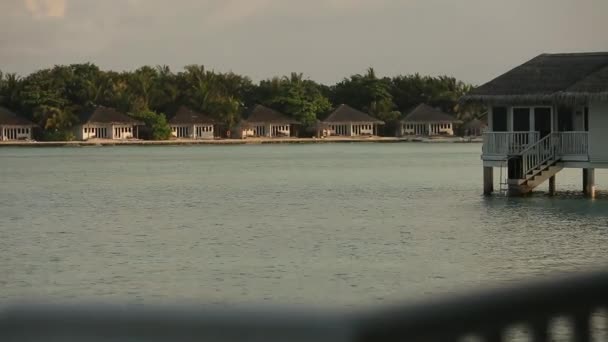 Pohled z tropické laguny s luxusní bungalovy nad vodou při východu nebo západu slunce na Maledivy — Stock video