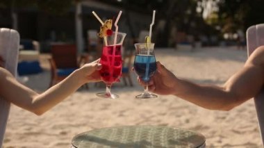 Güneşlenme ve içme genç aile çift tropikal beach adlı kokteyl renkli. Balayı Lovers da Okyanusu yakınlarındaki şezlong üzerinde güneşte yalan egzotik tatiller