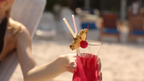 Junge Frau sonnt sich und trinkt farbigen Cocktail am tropischen Strand. Liebhaber verbringt Flitterwochen mit exotischem Urlaub in der Sonne liegend auf Liegestuhl am Meer — Stockvideo