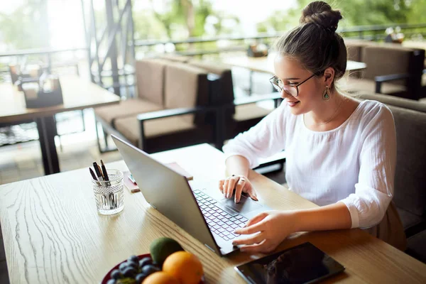 Young mixed race woman working with laptop in cafe at tropical location. Asian caucasian female studying using internet. Business woman doing social marketing work and shopping. Telecommuting concept. — Stock Photo, Image