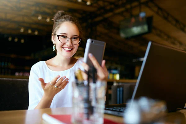 Freelancer surpreso mulher de raça mista olha para o smartphone e não pode acreditar que ela ganhou prêmio de loteria. bem sucedido assombrado ásia caucasiano empresária comunicando no vídeo chamada conferência chat . — Fotografia de Stock