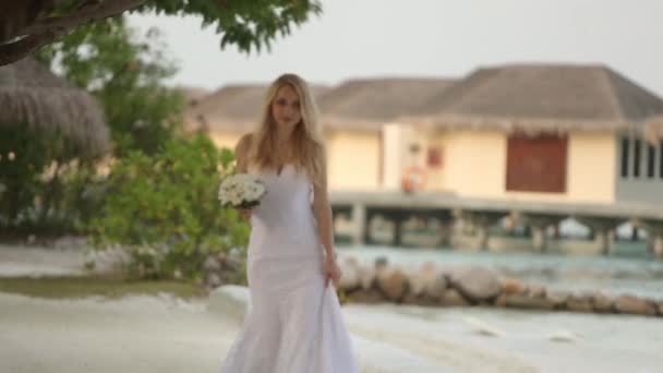 First look of young wedding couple. Bride goes to wedding ceremony on romantic tropical island on the white sand beach near azure lagoon ocean — Stock Video