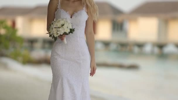 Der erste Blick des jungen Hochzeitspaares. Braut geht zur Trauung auf romantische tropische Insel am weißen Sandstrand in der Nähe des azurblauen Lagunenmeeres — Stockvideo