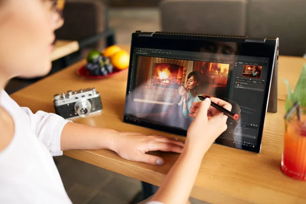 Freelancer retoucher vrouw werkt op convertible laptopcomputer met foto-editing software met stylus. Fotograaf of ontwerper digitale beeldverwerking. 2 in 1 met aanraakscherm in de tent modus. — Stockfoto