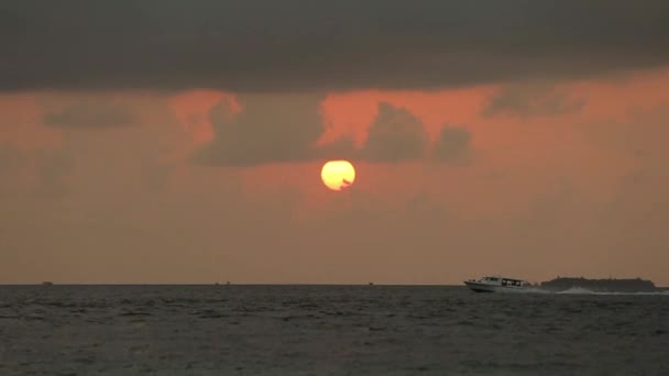 Matahari terbenam yang indah di atas laut. Kecepatan perahu di atas gelombang di cakrawala. Sinar matahari merah memantul di dalam air. Awan di langit. Matahari terbit saat matahari terbit . — Stok Video