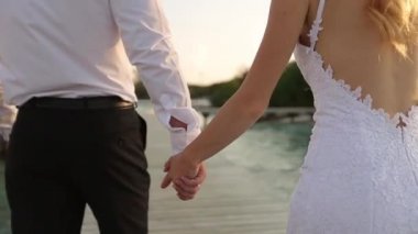 Onlar sahil hattı boyunca ve bungalov tarafından lüks spa Resort Maldivler adasında köprüde yürürken kamera gelin ve damat izler. Balayı zevk yeni evliler. Exotical tropik düğün kavramı.