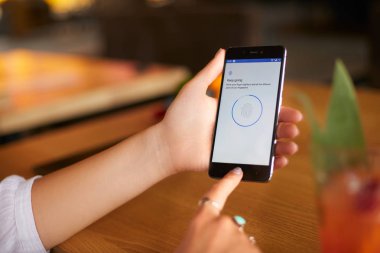Dizüstü bilgisayarda program komut dosyası ile onun akıllı kadın tarama parmak artalanları görüntüler. Kadın kilidini cep telefonu ile biyometrik duyumsal ve parmak. Gizlilik ve güvenlik kavramı.