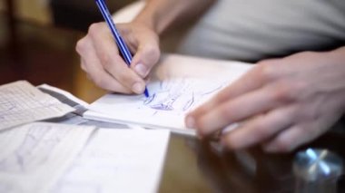 Giyim için tasarımcı çizim çizimler. Terzi stüdyoda çalışan yenilikçi tasarımcı moda proje çizimi. Erkek sanatçılar el kağıt kalem ile yeni bir elbise çizimi. Portre.