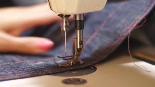 Primer plano macroplano de las manos femeninas que trabajan en la máquina de coser cerca de prensatelas y agujas. Mujer caucásica diseñador de moda cose vestido en el estudio de sastrería. Ocupación de costurera. Moda y sastrería . — Vídeos de Stock