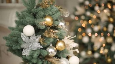 Şık beyaz yılbaşı dekorasyon dekore edilmiş köknar ağaçları ile. Konfor ile Noel ağacı altın süslemeleri, ışıklar ve çelenk ve lambalar dolu ev.