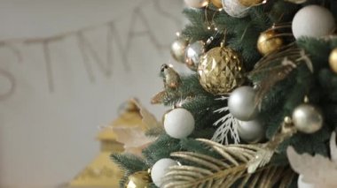 Şık beyaz yılbaşı dekorasyon dekore edilmiş köknar ağaçları ile. Konfor ile Noel ağacı altın süslemeleri, ışıklar ve çelenk ve lambalar dolu ev.