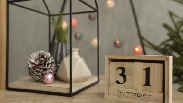 Elegantes detalles interiores escandinavos de Navidad. Hogar confortable con decoración nórdica de año nuevo. Ramas de abeto en jarrón, calendario de cubos de madera con figuras del 31 de diciembre y árbol de Navidad minimalista con — Vídeos de Stock