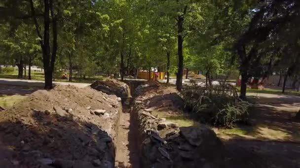 Luchtfoto van de loopgraven gegraven van pijpleidingen en communicatie op een bouwplaats. Water pijpleiding wederopbouw en basis in de stad. Quadcopter 4k-beeldmateriaal — Stockvideo