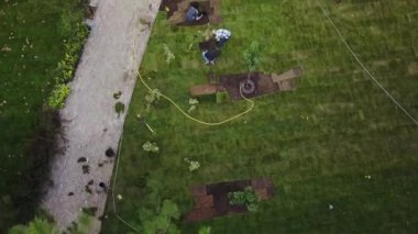 Parkta çim çim döşeme bahçıvan dron video. Havadan görüntüleri. Ağaç dikim işçilerin yukarıdan quadcopter görünümü görünüm.