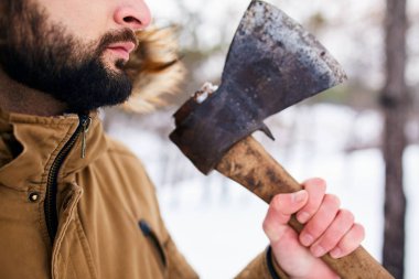 Sakal ve balta. Ormanda elinde balta ile ayakta oduncu. Görünümü Kapat, ormandaki tanınmayan adam.