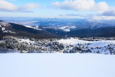 Dragobrat Kayak Merkezi yukarıdan panoramik manzaralı. Dağ karlı kış kayak pisti yataydan. Ahşap evler ve valley otelleri. Boş yamaç, insan yok. Ürün yerleştirme arka plan tasarımı için