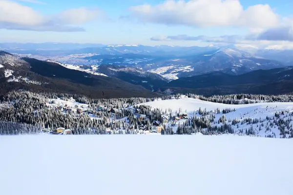 Panoramablick auf das Dragobrat Skigebiet von oben. Schneelandschaft von der Skipiste. Holzhütten und Hotels im Tal. Leere Pisten, keine Menschen. Produktplatzierung Hintergrund für Design — Stockfoto