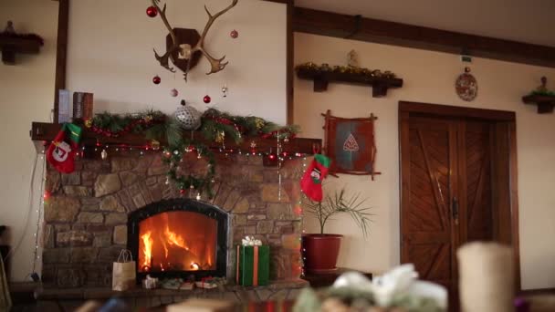 Quemadura de fuego en una chimenea decorada con luces de guirnalda, corona, medias y cajas de regalo en la víspera de Navidad. Celebración de fiestas de Año Nuevo. Dolly tiro 1080p Full HD . — Vídeos de Stock