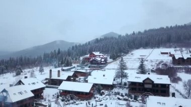 Kışın dağlarda yaşadığı yer, hava. Dağ köyü binalar ve evler karlı tepe yamaçlarında kar ile kaplı. Kırsal, köknar ağacı, çam ormanı. Kayak evler.
