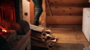 Örme kazak ahşap atma Genç şık adam evde şömine günlüğe kaydeder. Tanınmayan beyaz erkek ahşap soba Ocak ahşap günlük yazlık koyar. Adam bir şömine evinde boğuyor..