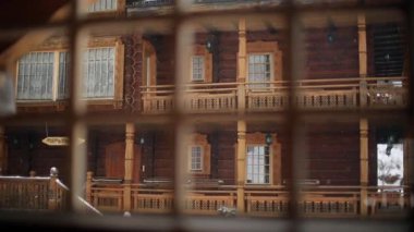Pencereden dışarı ahşap cephe görünümü yazlık Rus tarzı ile yoğun kar yağışı sırasında dağ köyünde asma ile oyulmuş. Kar günlüğü chalets adlı Kayak Merkezi düşüyor. Soğuk soğuk kış günü.