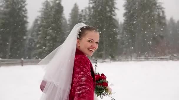 Young bride running to forest asking to follow her and having fun at ski resort village under heavy snowfall. Winter wedding inspiration and fairy tale. Honey moon follow me concept. Slow motion POV. — Stock Video