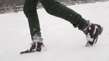 Düğün çift runing karlı kış kar yağışı sırasında. Taze kar üzerinde adım düşük açılı çekim ayak deri çizme. Kovalayan gelin damat. Balayı konsepti. Gelin giyiyor mercan şık elbise.