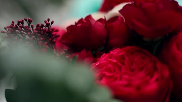 Bruden håller bukett blommor gjorda av vita och röda rosor. Nära makro skott av florist komposition. — Stockvideo