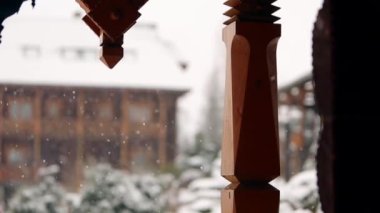 Kış arka plan bulanık. Ahşap evler iğne yapraklı herdem yeşil peyzaj tasarımı ile yoğun kar yağışı sırasında dağ köyünde. Kar günlüğü chalets adlı Kayak Merkezi düşüyor. Soğuk soğuk kış günü.