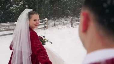 Genç gelin damat onu takip etmek ve yoğun kar yağışı altında rancho eğlenin soran orman için çalıştırıyor. Kış düğün ilham ve peri masalı. Ay tatlım ve kavram beni takip edin. Ağır çekim.