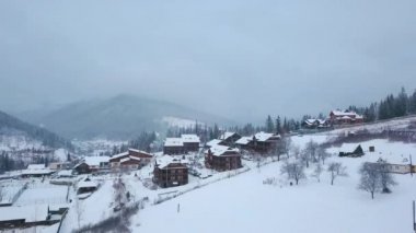 Kışın dağlarda yaşadığı yer, hava. Dağ köyü binalar ve evler karlı tepe yamaçlarında kar ile kaplı. Kırsal, köknar ağacı, çam ormanı. Kayak evler.