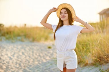 Spa sağlıklı plaj güzellik kadın rahatlatıcı ve plajda güneşlenme. Tatil seyahat tatil enjoting diş telleri ile güzel huzurlu ve huzurlu genç kadın modeli. Güneş koruma konsepti