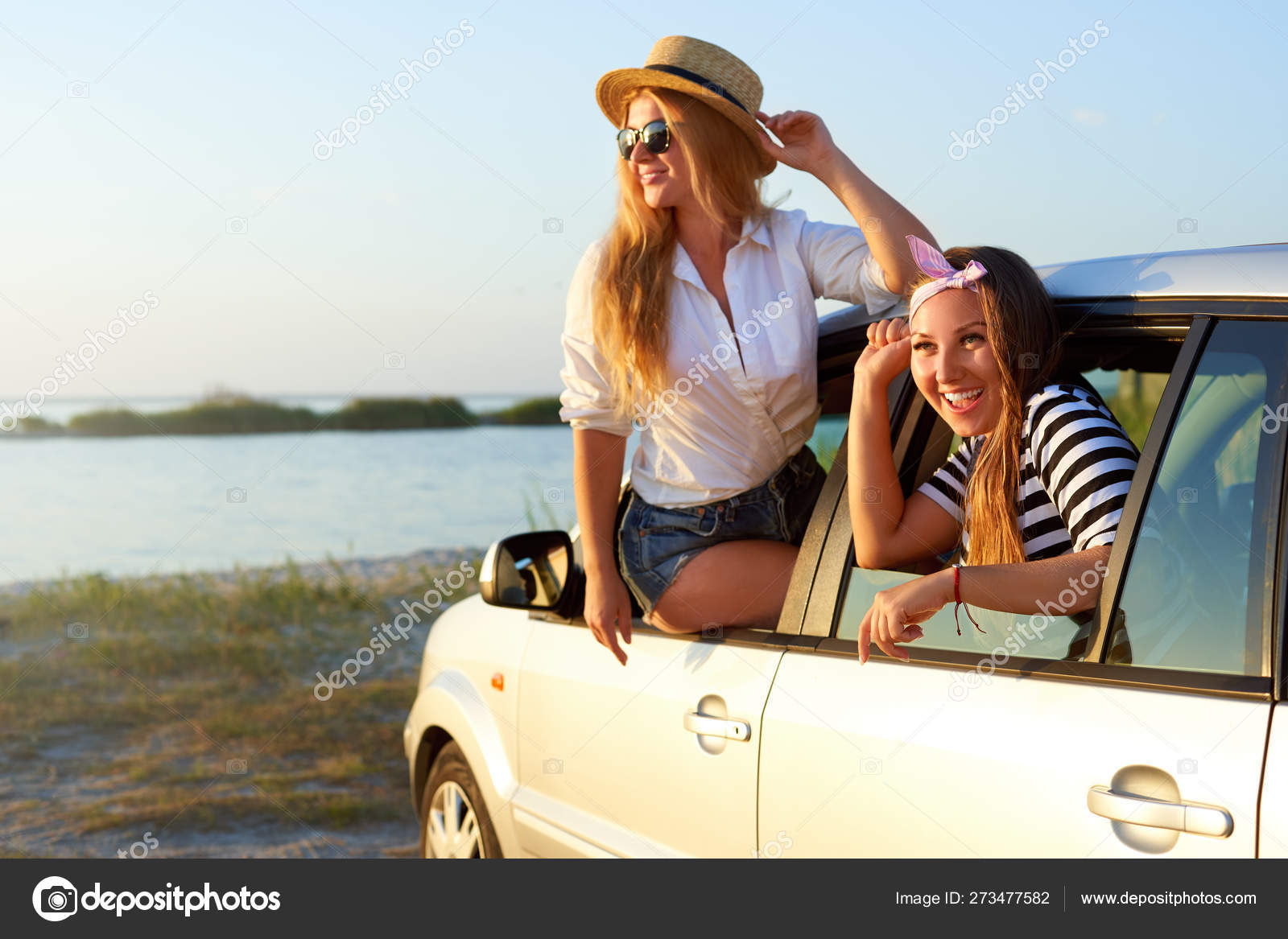 Two Women Enjoying Road Trip On A Summer Day At Seaside Excited