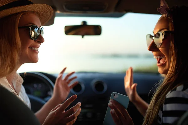 Feliz emocionado jóvenes mujeres que conducen en coche y haciendo alta cinco gesto en el viaje de vacaciones de verano. Dos chicas se alegran de haber llegado a la playa de destino. Vacaciones cerca del mar o el océano. Estilo de vida . —  Fotos de Stock