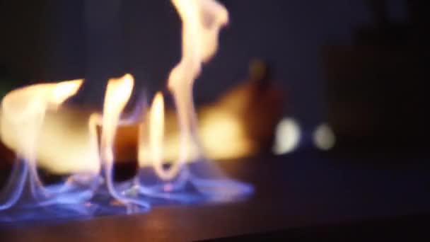 Оригинальный алкогольный коктейль, подаваемый в пабе или ночном клубе. Бармен, подающий выпивку стрелку в рюмке для клиента. Пламя горит на поверхности счетчика на черном фоне в замедленной съемке . — стоковое видео