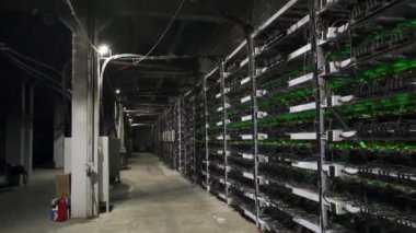 Büyük çiftlikteki kripto para madenciliği ekipmanları. ASIC madencileri sunucu odasında bitcoin 'i rafa kaldırıyor. Entegre devre engelleme teknolojisi uygulaması. Raflar boyunca sabit kamera görüntüleri.