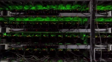 Büyük çiftlikteki kripto para madenciliği ekipmanları. ASIC madencileri sunucu odasında bitcoin 'i rafa kaldırıyor. Entegre devre engelleme teknolojisi uygulaması. Raflar boyunca sabit kamera görüntüleri.