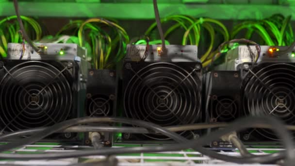 Cryptocurrency mining equipment on large farm. ASIC miners on stand racks mine bitcoin in server room. Blockchain techology application specific integrated circuit. Slider camera. — Stock Video