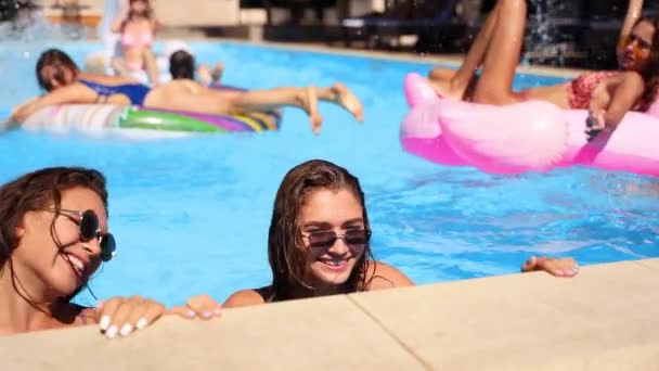 Heiße hübsche Mädchen im Bikini kriechen aus dem Swimmingpool. Freunde haben in einer Privatvilla gefeiert. Glückliche junge Leute planschen Wasser, tanzen mit Schwimmern im Luxus-Resort an sonnigen Tagen. Zeitlupe. — Stockvideo