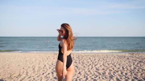 Pov siga-me tiro de mulher bonita levando namorado na praia tropical em direção ao mar. Menina atraente brincalhão em maiô e óculos de sol gira olhando para a câmera e chama para se juntar a ela. Movimento lento. — Vídeo de Stock