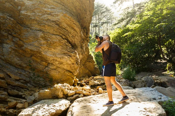 수염을 기른 사진사 가 숲 과산 사이를 거닐며 희미 한 카메라로 사진을 찍고 있다. 수평 모양, 복사 공간 — 스톡 사진