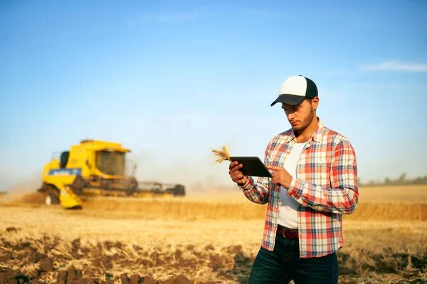 सटीक खेती। आधुनिक स्वचालन प्रणाली के साथ गठबंधन हारवेस्टर मार्गदर्शन और नियंत्रण के लिए किसान होल्डिंग टैबलेट। ऑनलाइन डेटा प्रबंधन सॉफ्टवेयर का उपयोग करने वाले कृषि विशेषज्ञ गेहूं क्षेत्र में उपज नक्शे उत्पन्न करते हैं — स्टॉक फ़ोटो, इमेज