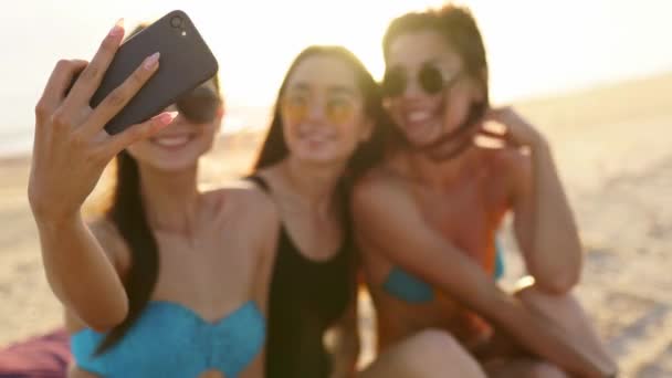 Amigos multirraciales sonrientes sentados juntos en toalla en la playa de arena blanca durante sus vacaciones en un destino idílico de la escena de la naturaleza. Hombres y mujeres se relajan en la orilla cerca del mar . — Vídeo de stock