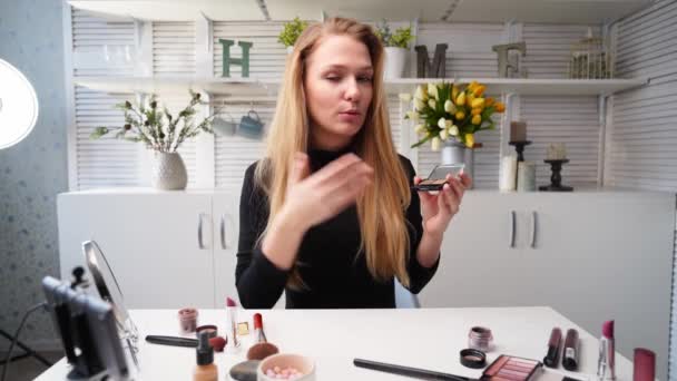Krása blogger žena natáčení denní make-up rutinní výuka na kameru. Influencer blondýny dívka živě streaming oční stíny paleta recenzi v domácím studiu s profesionálním osvětlovacím zařízením. Úloha Vloggeru. — Stock video